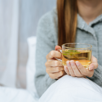 A person enjoying a healthy tea with Ayurvedic super-herbs.